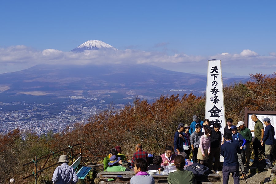 晩秋の金時山山頂。雪をかぶり、雲をまとった富士山が間近に